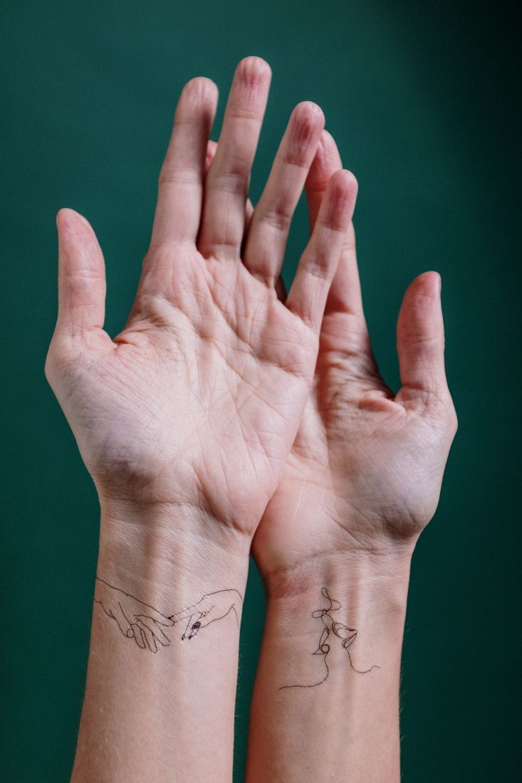 Small fine-line tattoos on both wrists